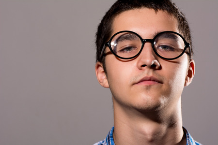 Close-up portrait Man in glasses with a serious expression on his face. Isolated on the gray...