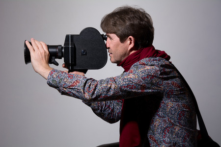 Portrait of a fashion cameraman with old movie camera.の写真素材