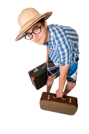 A young attractive man with glasses and two suitcases ready to travel. The stereotype of a foolish novice traveler. Portrait of a traveler in a full-length isolated on white backgroundの写真素材