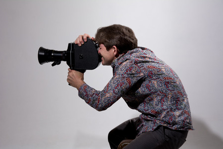 Portrait of cameraman with old movie camera.