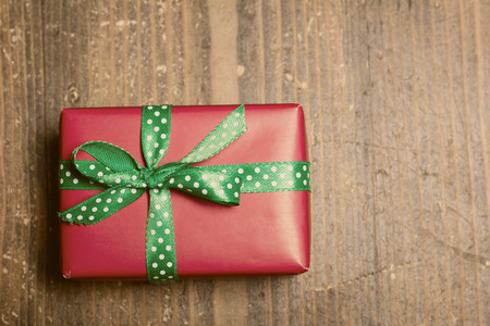 Red gift box lies on a wooden background. Vintage colorの写真素材