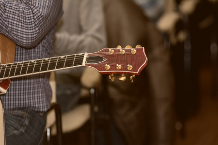 Fingerboard electric guitar close up on a background of seated spectators
