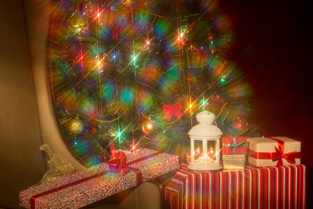 Christmas interior with illuminated Christmas tree and chair. Gifts at the Christmas tree. New Year's holiday. Spectacular nozzle with the starsの写真素材