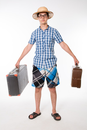 Young, handsome man in glasses with two old suitcase ready to travel. Portrait of a traveler in a full-length isolated on white backgroundの写真素材