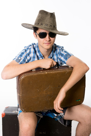 Portrait of young man in sunglasses with a suitcase.の写真素材