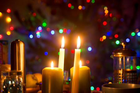Burning candles on a table against the background of colorful bokeh. Public Holiday.の写真素材