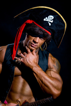 Close-up portrait muscular pirate in the studio on a dark background.の写真素材