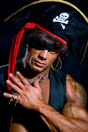 Close-up portrait muscular pirate in the studio on a dark background.の写真素材