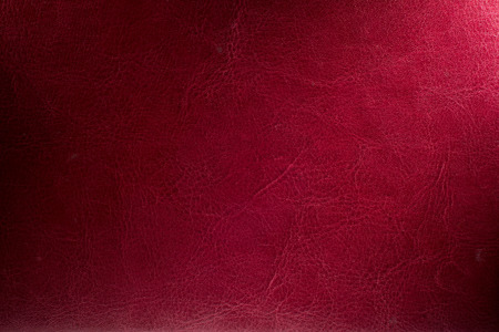 Red background illuminated from the right corner spotlight and vintage grunge background textureの写真素材
