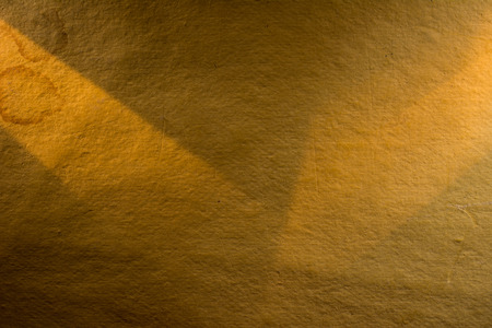 Yellow background illuminated from the left and right corner spotlight and vintage grunge background textureの写真素材
