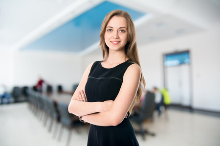 Portrait of a cute young business woman smiling, in an office environment.の写真素材