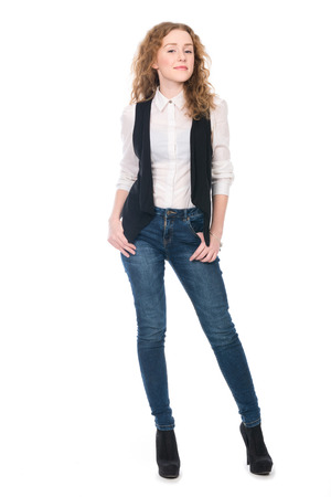 Portrait of young business girl with curly hair in jeans. Isolated on white in full lengthの写真素材