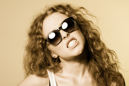 Pretty young capricious beautiful girl in sunglasses.の写真素材