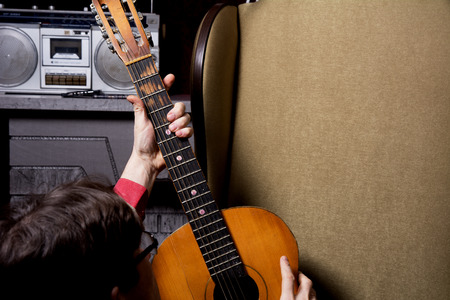 Man takes guitar. The decision to choose acoustic guitar instead of listening to the recordingの写真素材