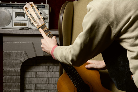 Man takes guitar. The decision to choose acoustic guitar instead of listening to the recordingの写真素材