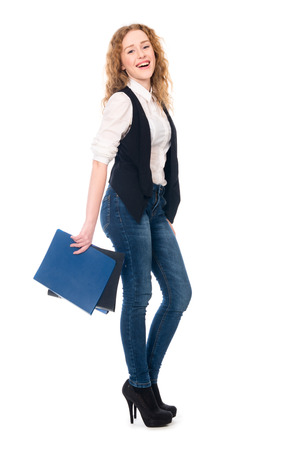 Portrait of happy young business woman. Cheerful secretary in full growth with folders. Isolated on white background.の写真素材