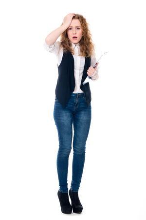 Astonished business woman with a writing tablet in full growth. Isolated on a white backgroundの写真素材