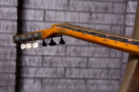 Grief acoustic guitar on the brick wall background.の写真素材