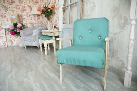 Interior room with green armchair, pillows, door and flowers. Room in retro style.の写真素材
