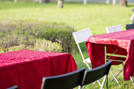 Empty tables and chairs outdoors in a park.