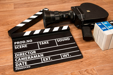 Old movie camera with a movie clapper and film. Preparations for shooting movieの写真素材