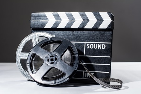 Film camera chalkboard and roll on white table. Accessories for shooting and film screeningsの写真素材