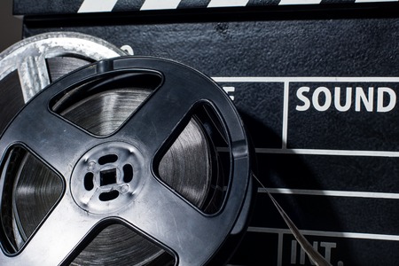 Close-up film camera chalkboard and roll on white table. Accessories for shooting and film screeningsの写真素材