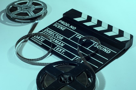 Two reels of film with a clap movie lying on a light table. Toned imageの写真素材