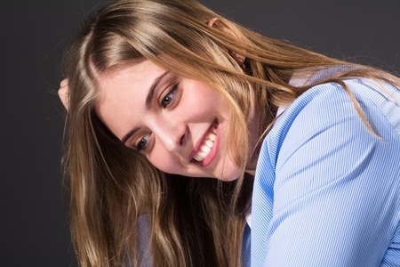 Close-up portrait of beautiful girl. Sensual woman in a shirt with straight hair looking aside.の写真素材