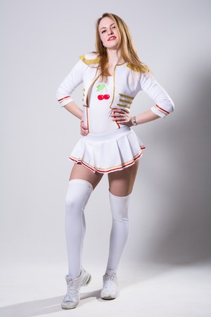 Cheerleader isolated on the white background. Young modern dancer in a pose full length in the studioの写真素材