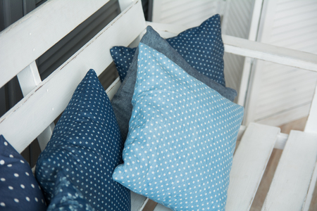 Close-up of blue cushions lie on a wooden trellis benchの写真素材