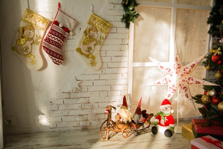 Christmas background wall with socks, Christmas tree and Santa with a snowman. Christmas background of a country houseの写真素材