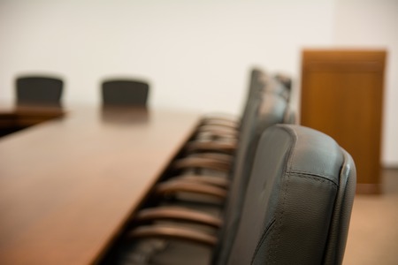 Back of chair around a wooden table in the boardroomの写真素材