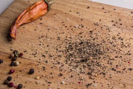 In the kitchen chopping board ground pepper and peas. Wooden background with chilli menuの写真素材