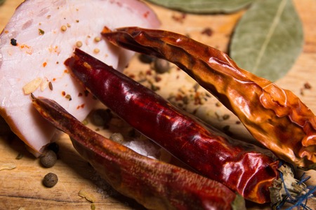 Background red peppers with a slice of bacon on a boardの写真素材