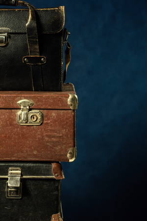 Stack of old suitcases. Travel Concept Background longer trips. Wardrobe trunk photographer reportage on a blue backgroundの写真素材