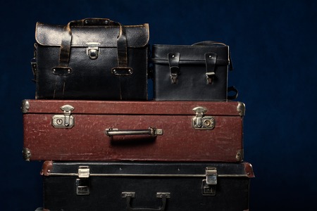 Background stack of old suitcases. Travel Concept Background longer trips. Wardrobe trunk photographer on a blueの写真素材