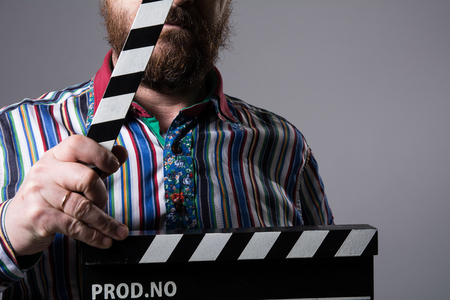 Man with clapperboard cinema. Bearded man movie production assistantの写真素材