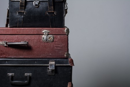 Background stack of old suitcases. The concept of traveling long journeys. Wardrobe trunk photographer reportage on grayの写真素材
