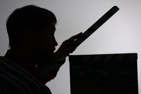 Silhouette of man with clapper movie. Assistant to the shooting sceneの写真素材