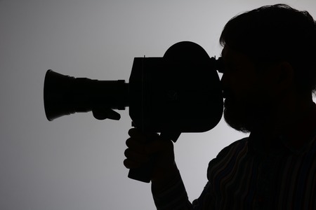 Silhouette of a bearded man in the side of the camcorder. cinema operator, documentary TVの写真素材