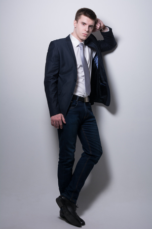 Portrait of a business man in full growth on gray background. Young fashion man in a suit in the studioの写真素材