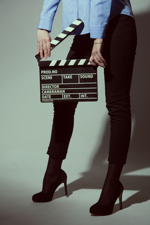 Woman with movie clapper. Girl helps in shooting a movie.の写真素材