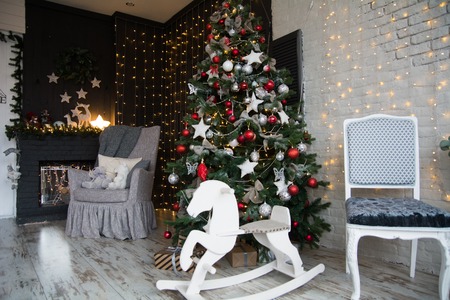 Decoration with Christmas tree, fireplace and child wooden horse. Background for a New Year's greeting cardの写真素材