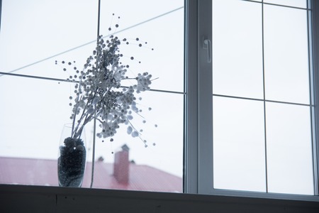 Vase with flower arrangement on the windowsill. Interior design of the room for relaxation.の写真素材