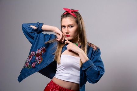 Young serious woman in colorful dress. Fashion girl looking at the camera on a gray backgroundの写真素材
