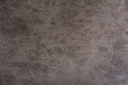 Background of dark-colored leather with an abstract pattern. A new cloth with an uneven surfaceの写真素材