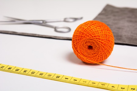 Background for tailor orange thread and sewing tools. Scissors and measuring tapeの写真素材
