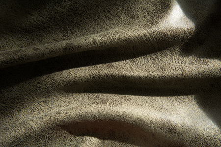 Close-up of a fold of fabric with an abstract pattern illuminated by lightの写真素材