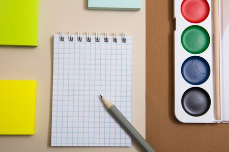 Notepad with pencil sticky paper for snakes and watercolor paints. Blocks of paper for recording on a delimited surfaceの写真素材